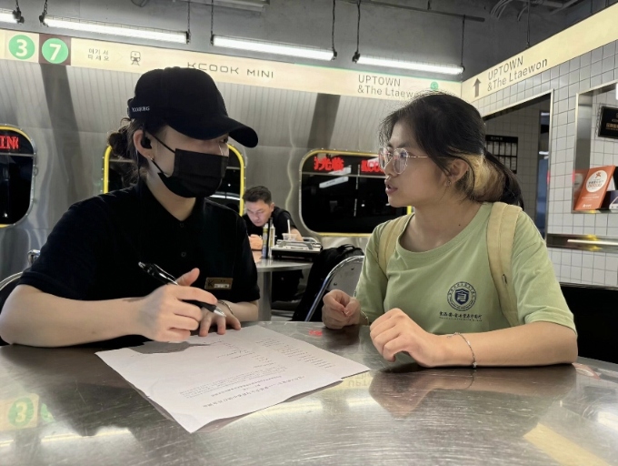 實(shí)踐團(tuán)與餐飲店服務(wù)員進(jìn)行民意調(diào)查(付欣然攝)