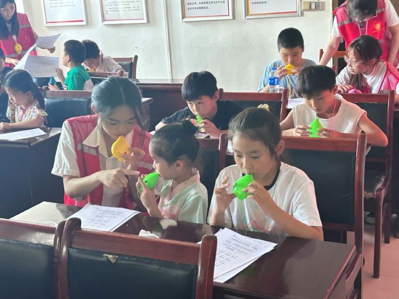 圖為志愿者與小朋友一起吹陶笛